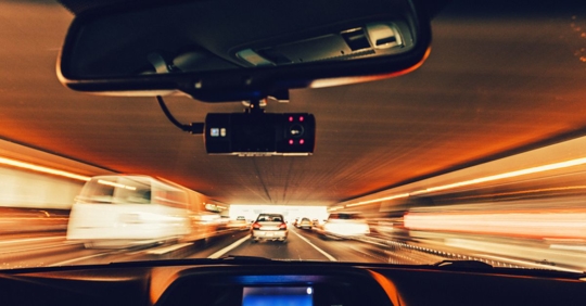Driving through an overpass tunnel with a dashcam in the car.